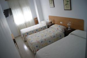 卢戈格然维阿酒店的一间卧室设有两张床和窗户。