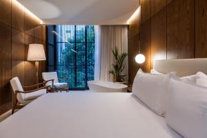 麦德林Elcielo Hotel & Restaurant的卧室设有白色的床和大窗户
