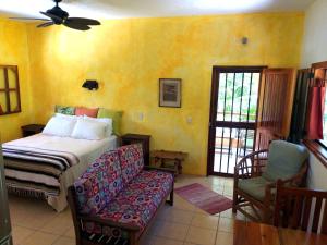 El PlacerMayan Beach Garden的一间卧室配有一张床、一张沙发和一个窗口