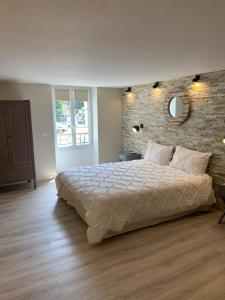马赛Marseille City Chambres&Appartements的一间卧室设有一张大床和砖墙