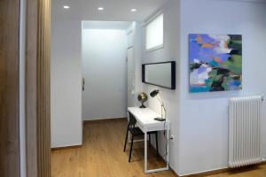 塞萨洛尼基LightHouse 17的白色的客房配有带台灯和绘画的书桌