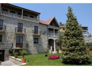 Lestrove卡萨安蒂加杜蒙特酒店的一座大石头建筑,院子里有一棵圣诞树
