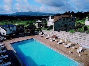 Lestrove卡萨安蒂加杜蒙特酒店的一座带躺椅的大型游泳池和一座建筑