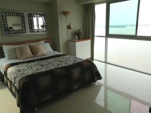 瓜亚基尔River View Suites Guayaquil的一间卧室设有一张床和一个大窗户