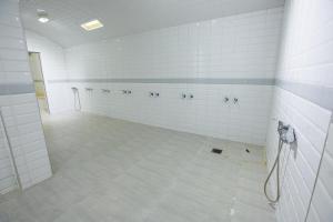 丹吉尔Motel Gzenaya的大型浴室设有白色瓷砖墙壁和淋浴。