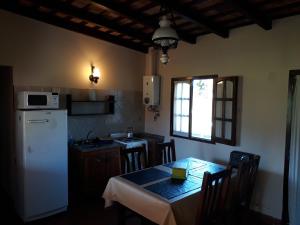 费德拉西翁莱斯阿奇拉斯乡村民宿的厨房配有桌子和白色冰箱。
