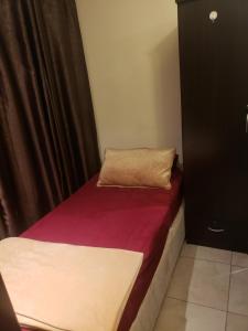 迪拜Hostel Dubai的小房间,配有床和窗帘