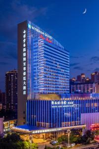 昆明七彩云南温德姆至尊豪廷大酒店 的一座高大的建筑,上面有蓝色的灯光