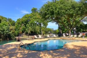 新布朗费尔斯Grandmas River Haus RRC A108的公园内的游泳池,有椅子和树木