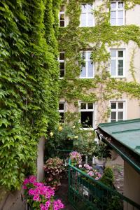 维也纳施瓦尔贝酒店的一座常春藤覆盖的建筑,前面有鲜花