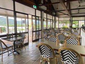 埃尔利海滩殖民地棕榈汽车旅馆的餐厅设有桌椅和窗户。