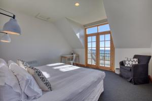 比那隆湾Monterey Bay of Fires的卧室配有床、椅子和窗户。