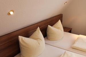 罗滕堡厄赫酒店的两个枕头坐在房间里的床边