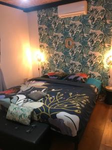 珀蒂蒂勒La Villa Citronnier的一间卧室配有一张带花卉壁纸的床
