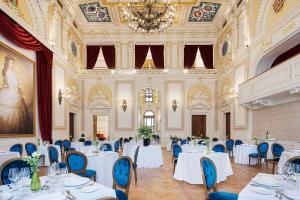 布达佩斯Áurea Ana Palace by Eurostars Hotel Company的宴会厅配有白色的桌子和蓝色的椅子