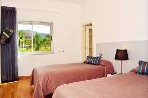 波多黎各欧泊安菲陶罗别墅的酒店客房设有两张床和窗户。
