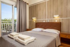 法里拉基里亚酒店的一间卧室配有带毛巾的床
