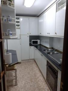 乌贝达Casa Manuel的厨房配有白色橱柜和水槽
