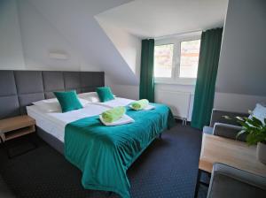 伊斯泰布纳Kompleks Zagroń Istebna的酒店客房带一张大床,带绿色窗帘