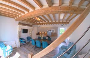 Pertheville-NersAu pré des acajous的客厅设有木制天花板和蓝色椅子
