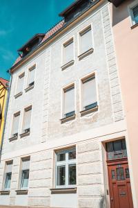 奎德林堡4 Sterne Ferienwohnung , 65 qm的白色砖砌建筑,设有红门