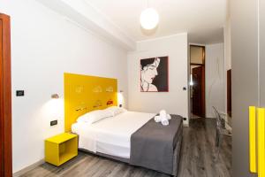 都灵克丽斯塔罗都灵诺酒店的卧室配有白色的床和黄色的墙壁
