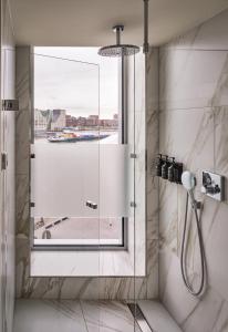 阿姆斯特丹Sir Adam Hotel, part of Sircle Collection的带淋浴的浴室和窗户