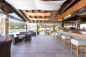 罗达Amorossa Beachfront Village by Konnect, Roda Corfu的餐厅设有酒吧和桌椅