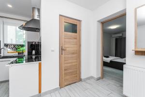 斯图托沃VIP House Apartamenty的厨房设有通往卧室的门