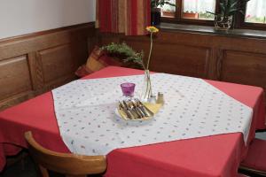 罗滕堡加斯特霍夫布茨酒店的红白桌子,上面有花瓶的盘子
