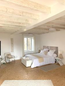 La Chapelle-de-GuinchayLe Domaine的白色卧室配有一张大床和椅子