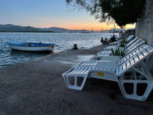 克勒克Apartments Ljiljana的湖岸上的一排白长椅