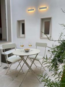 莫诺波利Dimore Garibaldi - Puglia Mia Apartments的一张带两杯葡萄酒的白色桌子