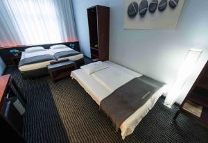美因河畔法兰克福协和酒店的酒店客房,设有两张床和一盏灯
