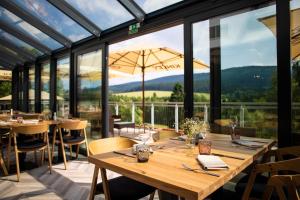德尔内夫奥里克Amenity Hotel & Resort Orlické hory的用餐室配有桌椅和大窗户