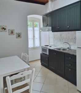 StavrosSpilia的厨房配有黑色橱柜和白色台面