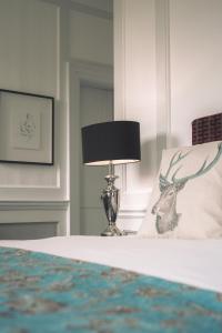 胡克Warbrook House Heritage Hotel的一间卧室配有一张床,上面有灯