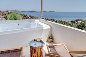 阿佐里姆诺斯法罗斯度假村 的一间带浴缸和椅子的浴室,享有海景。
