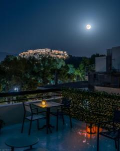 雅典Acropolis Vision的夜间阳台上的桌椅