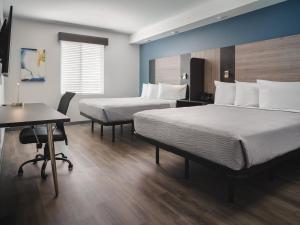 达拉姆stayAPT Suites Raleigh-Durham/RTP的酒店客房配有两张床和一张书桌
