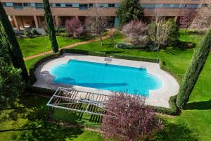 马德里Las Encinas Design Apartment in Conde Orgaz - Madrid的享有庭院游泳池的顶部景色