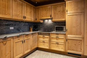 大格迈因“卡塞卡尔”公寓的一间带木制橱柜和微波炉的厨房