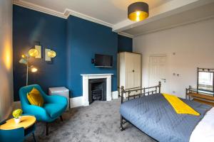 金斯林BrickSage Rooms, King's Lynn South Gate的卧室拥有蓝色的墙壁,配有一张床和椅子