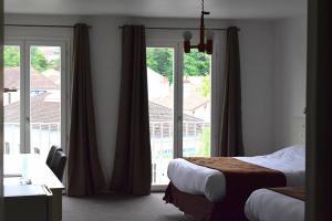 波旁莱班劳力尔玫瑰酒店的酒店客房设有两张床和大窗户。