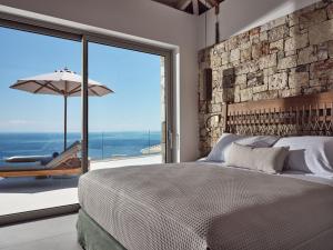 圣尼古拉奥斯Etheria Luxury Villas & Suites的一间卧室设有一张床和一个大窗户