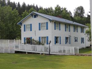 Sweet Home福斯特湖宾馆的白色的房子,设有蓝色的窗户和白色的围栏
