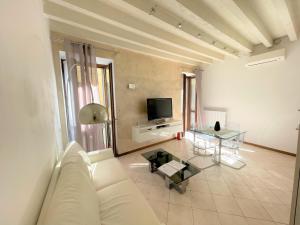 代森扎诺-德尔加达DesenzanoLoft Le Petit Bijou Desenzano的客厅配有白色沙发和电视