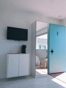 佩尔塞En route vers l’infini的客厅配有平面电视和蓝色门。