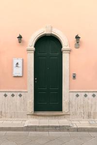 圣潘克拉齐奥萨伦蒂诺Antico Borgo的粉红色建筑上的绿色门