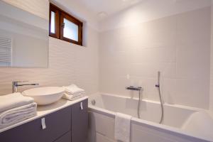 卡尔卡松Les Pimprenelles的白色的浴室设有浴缸、水槽和浴缸。
